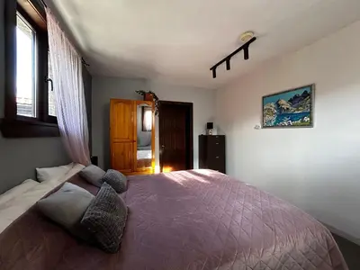 a bedroom with a bed and a window at Devonshire Lodge Chalet in Bansko