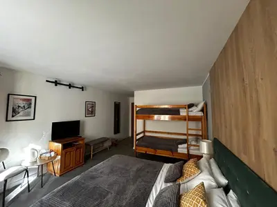 a bedroom with two bunk beds and a television at Devonshire Lodge Chalet in Bansko