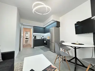 a living room with a table and a kitchen at Diamond Apartment in Plovdiv