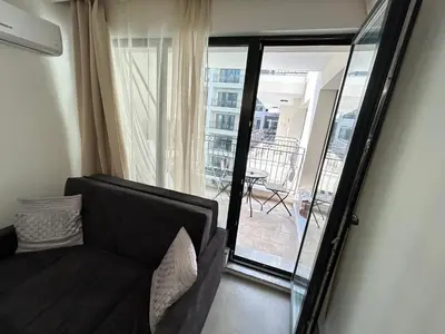 a living room with a couch and a balcony at Diamond Apartment in Plovdiv