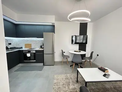 a kitchen with black cabinets and a table and chairs at Diamond Apartment in Plovdiv