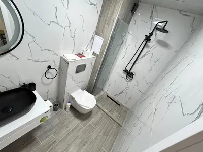 a white bathroom with a toilet and a shower at Diamond Apartment in Plovdiv
