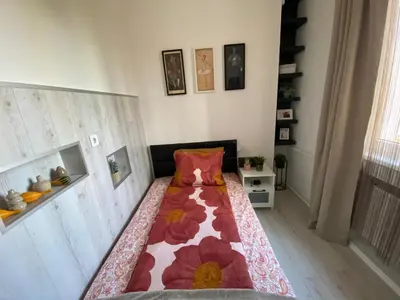 a bedroom with a bed with a flower blanket on it at Apartment PS in Sofia