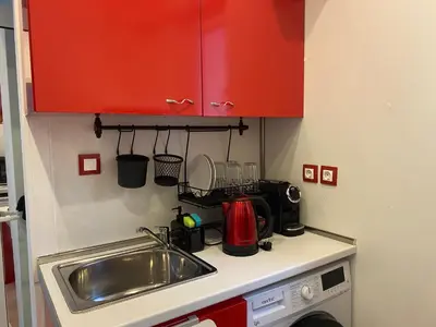 a kitchen counter with a sink and red cabinets at Apartment PS in Sofia