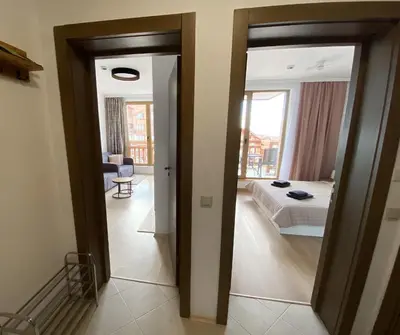 a room with a bedroom with a bed and a mirror at ELDORA Deluxe Private Apartment in Bansko