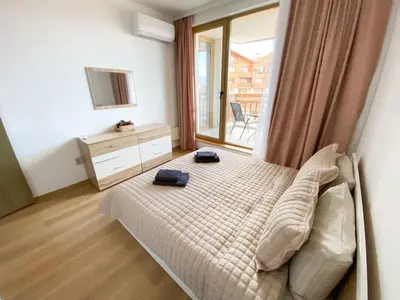 a bedroom with a bed and a large window at ELDORA Deluxe Private Apartment in Bansko