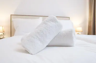 a pile of towels sitting on top of a bed at Comfort 1 Bedroom App in Plovdiv