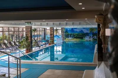 a large swimming pool in a hotel with a large painting on the wall at Hotel Paradise in Ognyanovo