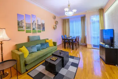 a living room with a green couch and a tv at Cozy Central Apartment By NDK and Vitosha Blvd with Free secured parking and two terraces in Sofia