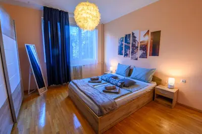 a bedroom with a bed and a chandelier at Cozy Central Apartment By NDK and Vitosha Blvd with Free secured parking and two terraces in Sofia