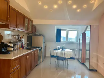a kitchen with a table and a table and chairs at Prime Center - 1BDR Apt - Top Floor Next to the National Stadium & Sofia University in Sofia