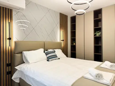 a bedroom with a large white bed with a chandelier at 2BR Apartment in a Modern Complex with free Street Parking in Plovdiv
