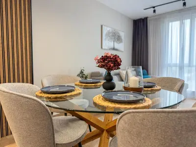a dining room with a glass table and chairs at 2BR Apartment in a Modern Complex with free Street Parking in Plovdiv