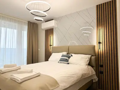 a bedroom with a large bed with white sheets at 2BR Apartment in a Modern Complex with free Street Parking in Plovdiv