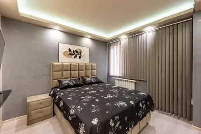 a bedroom with a bed and a large window at Beni Deluxe 1 in Plovdiv
