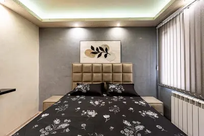 a bedroom with a bed with a black and white bedspread at Beni Deluxe 1 in Plovdiv