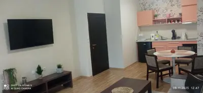 a living room with a table and a tv on a wall at СПА апартамент 