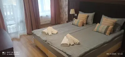 a bedroom with a large bed with towels on it at СПА апартамент 