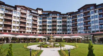 a large building with a fountain and umbrellas at СПА апартамент 