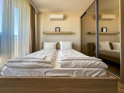 a large white bed in a room with a mirror at Quiet & Comfortable Urban Retreat in Sofia