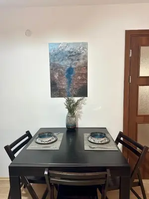 a black table with two plates and a vase on it at Alpine Apartment Home2Host in Bansko