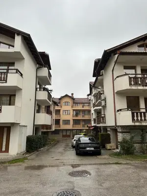 a car parked in a parking lot between two buildings at Alpine Apartment Home2Host in Bansko