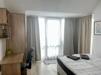 a bedroom with a bed and a desk and a window at Cozy apartment Alba with two bedrooms! in Blagoevgrad