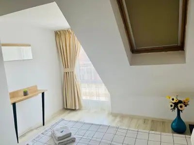 a room with a vase of flowers and a window at Cozy apartment Alba with two bedrooms! in Blagoevgrad