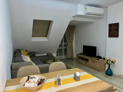 a living room with a couch and a tv at Cozy apartment Alba with two bedrooms! in Blagoevgrad
