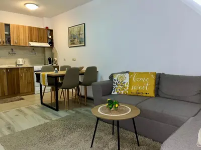 a living room with a couch and a table and a kitchen at Cozy apartment Alba with two bedrooms! in Blagoevgrad