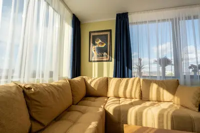 a living room with a couch in front of a window at Rila Sunshine Apartment in Samokov