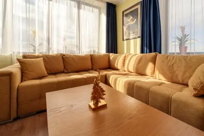 a living room with a brown couch and a coffee table at Rila Sunshine Apartment in Samokov