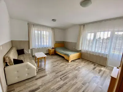 a living room with a couch and a bed at Къща за гости 