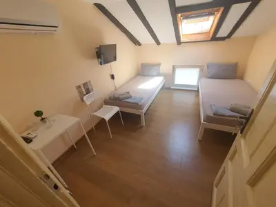 a room with two beds and a table and chairs at Let's Go Party - Plovdiv Center in Plovdiv