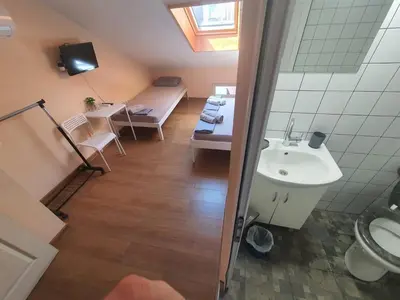 a small bathroom with a sink and a bed at Let's Go Party - Plovdiv Center in Plovdiv