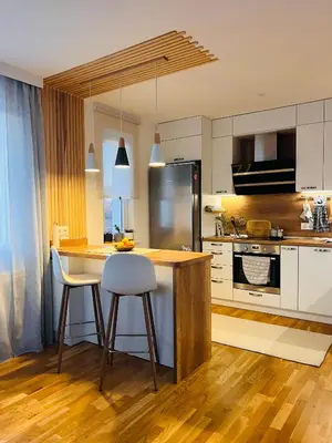 a kitchen with a island with a counter and chairs at Cosy Dream Appartment near Borovets in Samokov