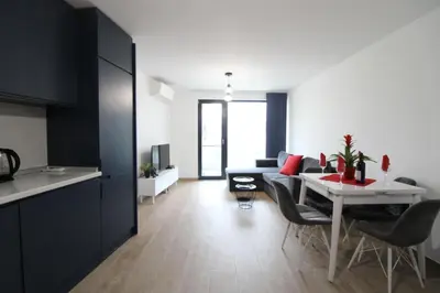 a kitchen and a living room with a table and chairs at Modern 1BR Apartment Plovdiv City Center Parking in Plovdiv