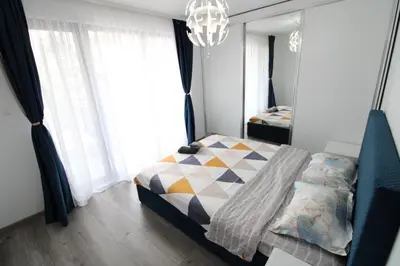a bedroom with a bed and a chandelier at Modern 1BR Apartment Plovdiv City Center Parking in Plovdiv