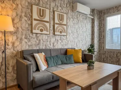 a living room with a couch and a table at One-Bedroom Apartment next to Mall Plovdiv with Free Street Parking in Plovdiv