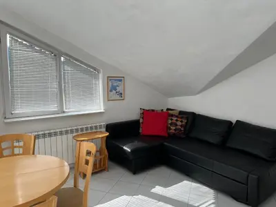 a living room with a black couch and a table at Iglika 2 Top Floor apartment in Borovets