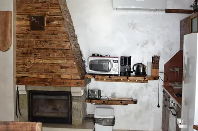 a kitchen with a microwave and a fireplace at Villa Pamporovo in Pamporovo