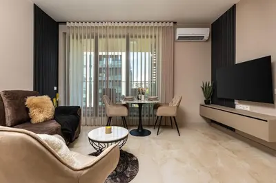 a living room with a couch and a table at Royal Garden apartment with Private Parking in Plovdiv