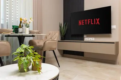 a living room with a television and a table at Royal Garden apartment with Private Parking in Plovdiv