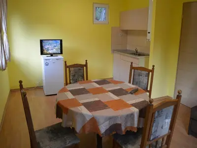 a kitchen with a table and a small refrigerator at Guest House Rainbow in Cherni Osŭm