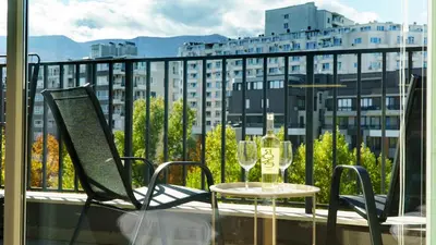 a balcony with a table and two glasses of wine at The BlackPeak View Apartment in Sofia