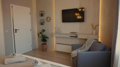 a living room with a couch and a flat screen tv at LUXURY Designer Apt I Meters to Gondola Lift I Sleeps 6 I Pool & Parking I in Bansko