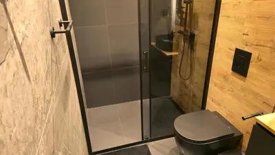 a bathroom with a toilet and a glass shower at LUXURY Designer Apt I Meters to Gondola Lift I Sleeps 6 I Pool & Parking I in Bansko