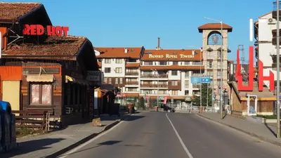 an empty street in a city with a clock tower at LUXURY Designer Apt I Meters to Gondola Lift I Sleeps 6 I Pool & Parking I in Bansko
