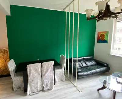 a living room with a green wall and a couch at Happy Appointment in Sofia