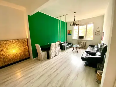 a living room with a green wall and a couch at Happy Appointment in Sofia